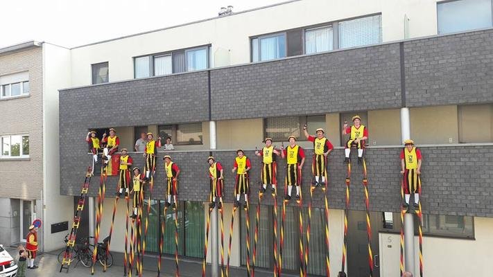 Steltenlopers op een rij tegen een grijze gevel