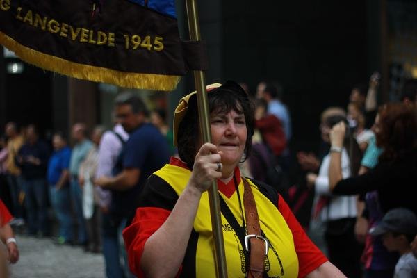 Vaandeldraagster in kostuum tussen het publiek