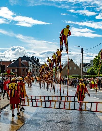 Steltenlopers en een ladder in de stoet door de straat