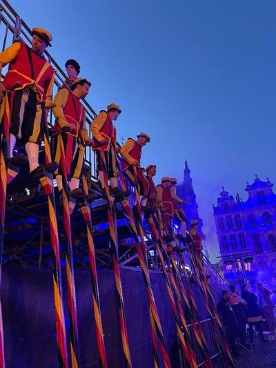 Steltenlopers op een tribune bij avond op de Grote Markt van Brussel