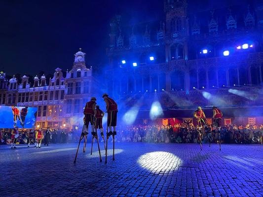 Twee duo's steltenlopers op de verlichte Grote Markt