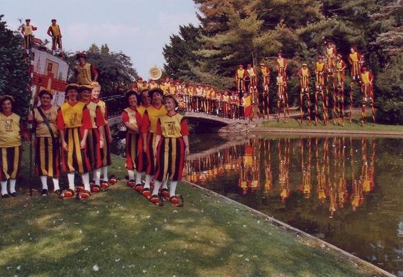 Oude kleurenfoto van de groep in kostuum bij een vijver