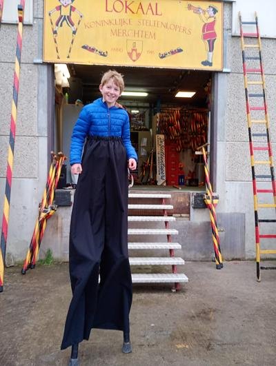 Kind op stelten met lange broek voor het lokaal