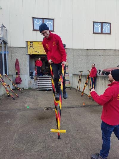 Beginner leert stappen op stelten met hulp van een trainer